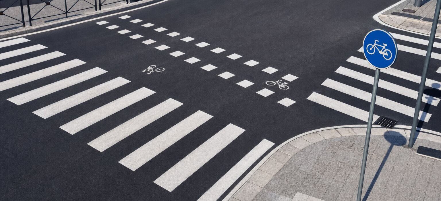 Attraversamento ciclabile segnato sull asfalto con due file di quadrati bianchi accanto alle strisce pedonali